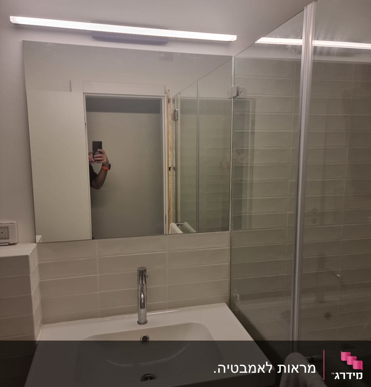 מראה גדולה מעל כיור, דלת זכוכית למקלחת